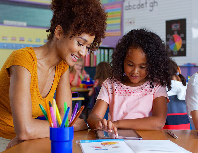 Teacher helping students at a classroom table